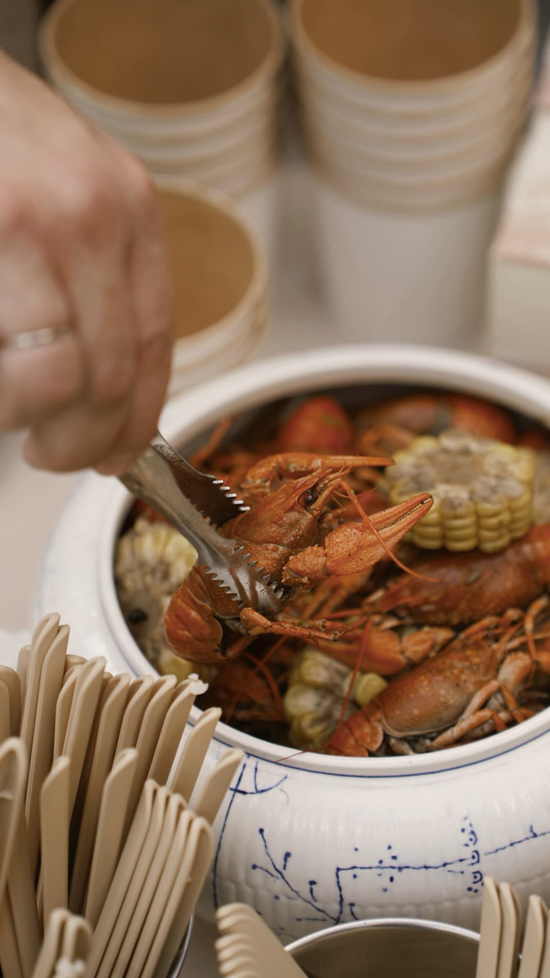 Крупный план раков с кукурузой, подача щипцами